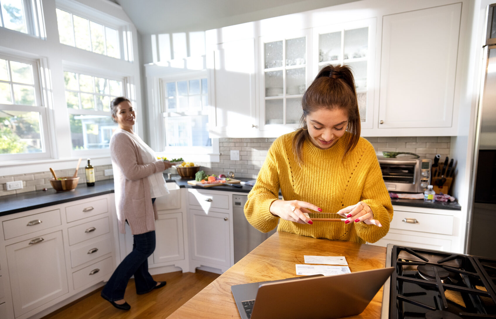 A teenage girl scans her paycheck with her cell phone.