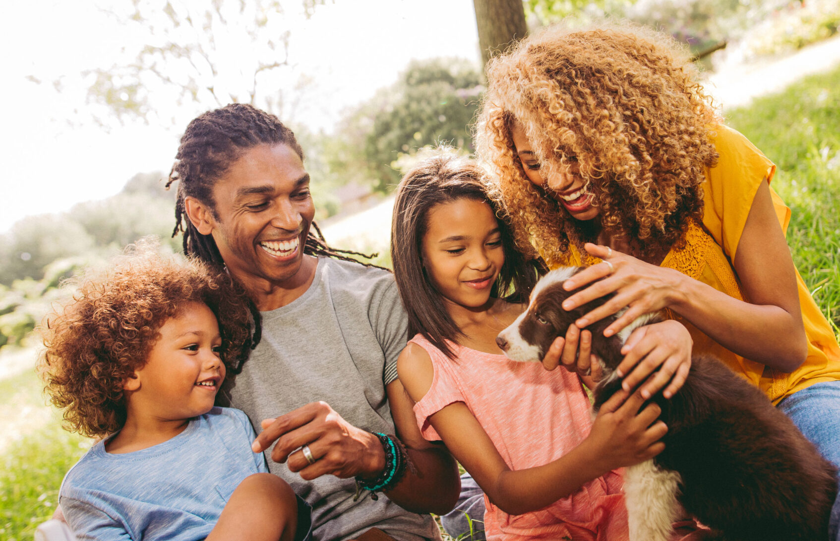 A happy young family as they gather around a puppy.