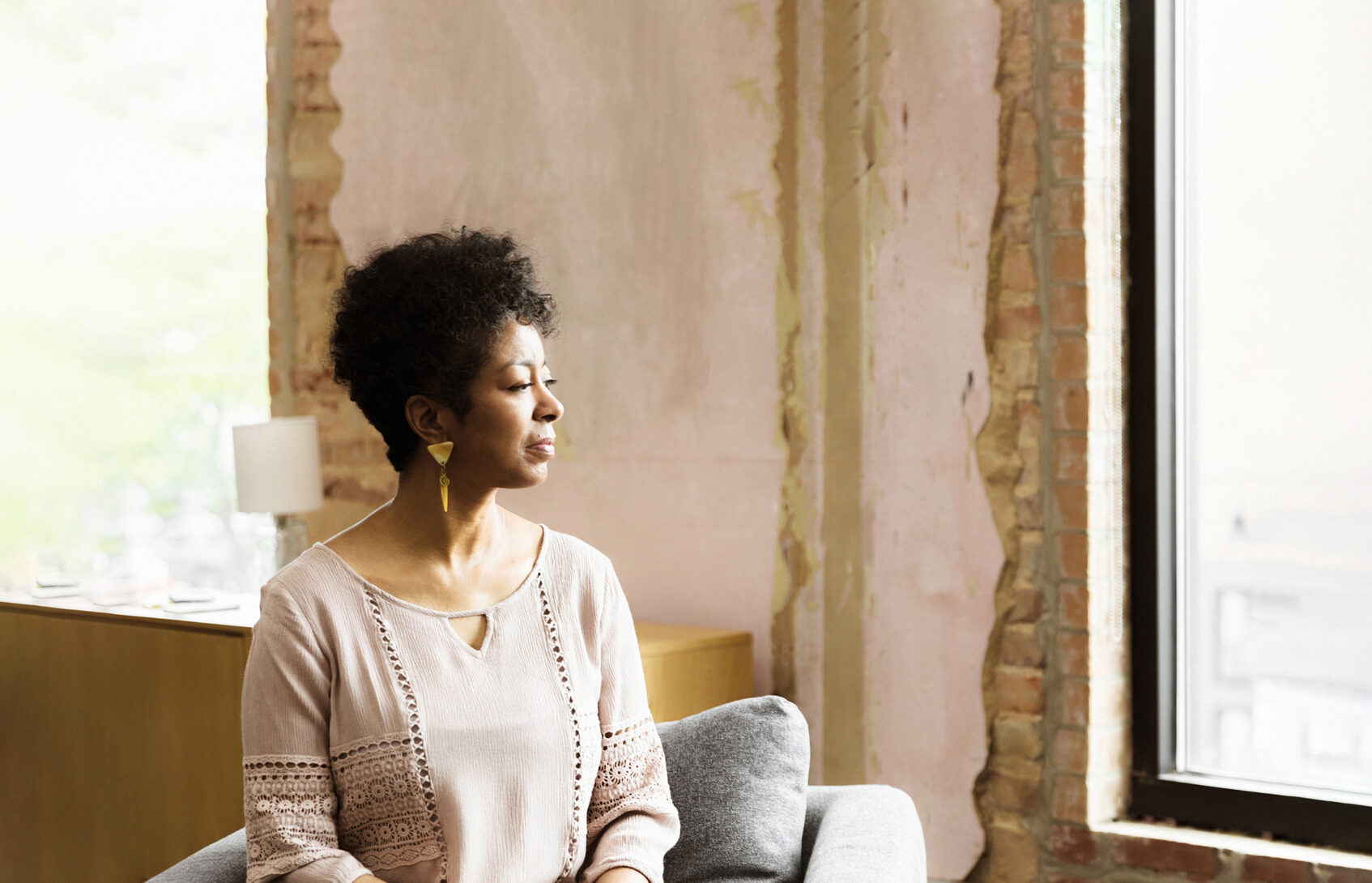 Woman seated in the living room looking out the window