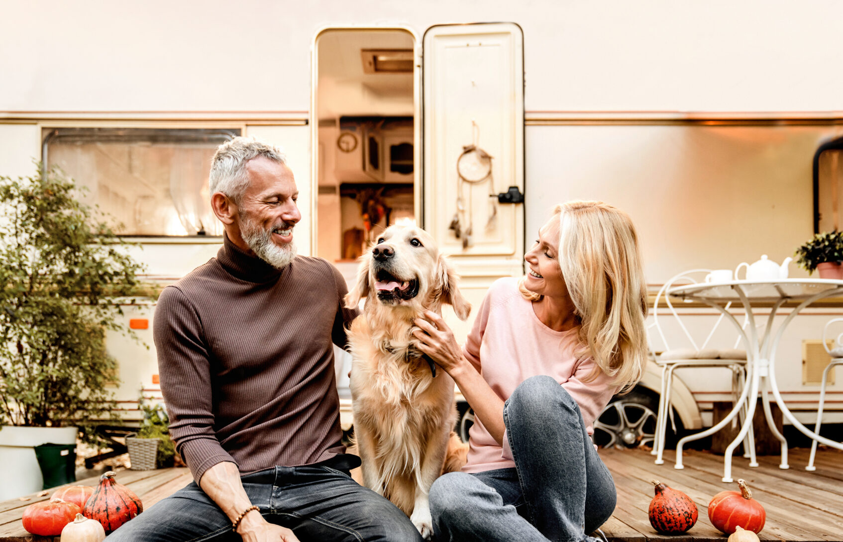 A man and woman sitting together on a deck with their dog