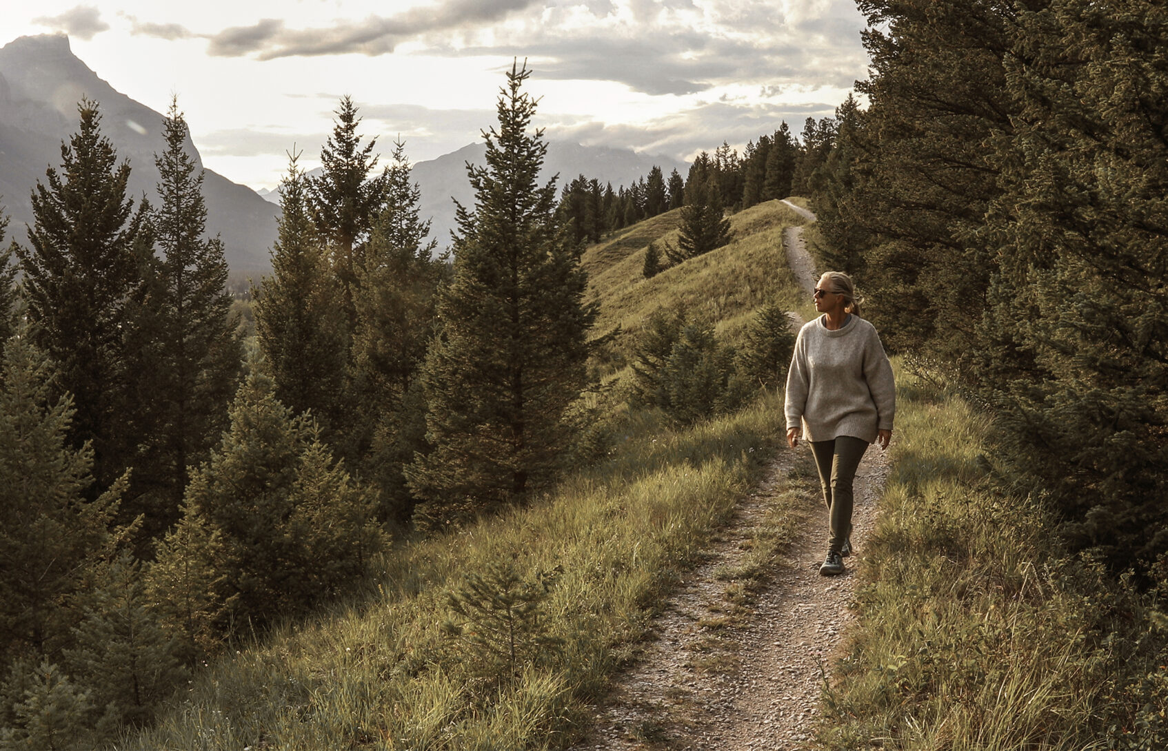 Woman walks down trail in the morning.