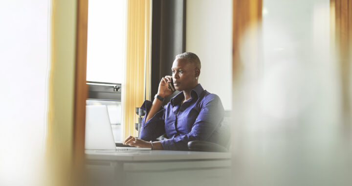 Woman seated at her desk with phone in hand